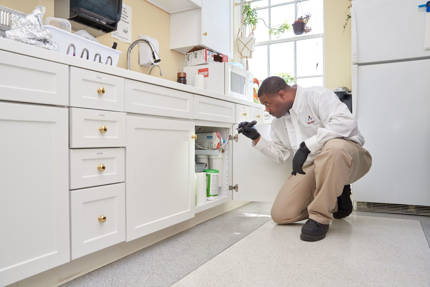 Sp inspects under a kitchen sink